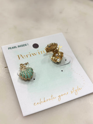 Whimsical coastal charm meets playful design with these unique shell drop earrings. Featuring gold-tone seashell silhouettes that open magnetically to reveal a hidden pearl inside, this pair adds a delightful surprise to any look. Finished with soft aqua enamel detailing and lightweight movement, they’re perfect for adding personality, charm, and a touch of magic to everyday outfits.