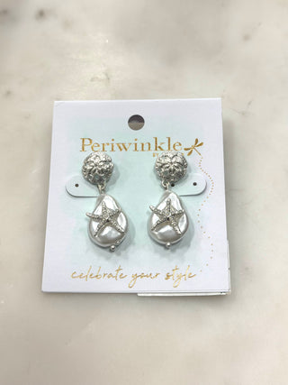 Coastal glamour meets playful sparkle with these statement drop earrings. Featuring textured silver-tone studs paired with luminous pearl-style drops and starfish accents, this pair brings seaside charm and eye-catching shine to any look. Lightweight with graceful movement, they’re perfect for adding a fun, ocean-inspired touch to everyday outfits or special occasions.