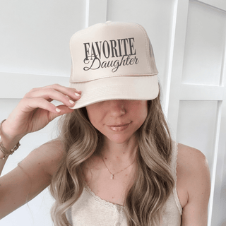 Meet your new everyday favorite 🤍 This “Favorite Daughter” trucker hat is the perfect mix of playful, trendy, and effortlessly cool. Designed in a versatile tan color, it’s the easy accessory that pulls any casual look together—whether you’re running errands, heading out for the day, or just keeping it laid-back. The breathable mesh back and adjustable snapback make it as comfortable as it is cute.

Details you’ll love:
• Tan colorway with “Favorite Daughter” front design
• Mid-profile, structured fit
