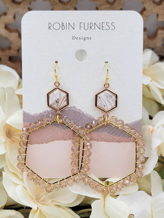Pair of gold and crystal earrings on a 'Robin Furness Designs' card with flowers in the background.
